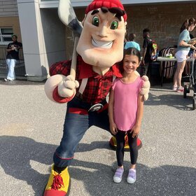 une élève et la mascotte à la fête champêtre
